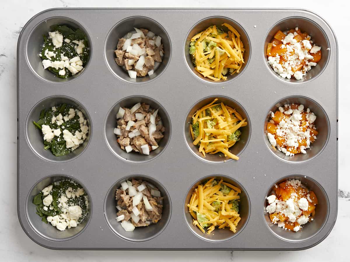 Cheese, meat, and vegetables in muffin tin. 