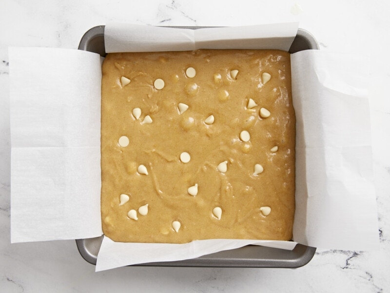 Blondie batter added to a parchment lined baking dish.