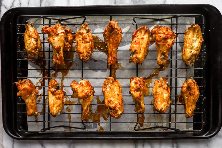 baked chicken wings on a wire rack set in a baking sheet.