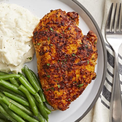 Overhead view of Air Fryer Chicken Breast on a plate with a side of mashed potatoes and green beans.