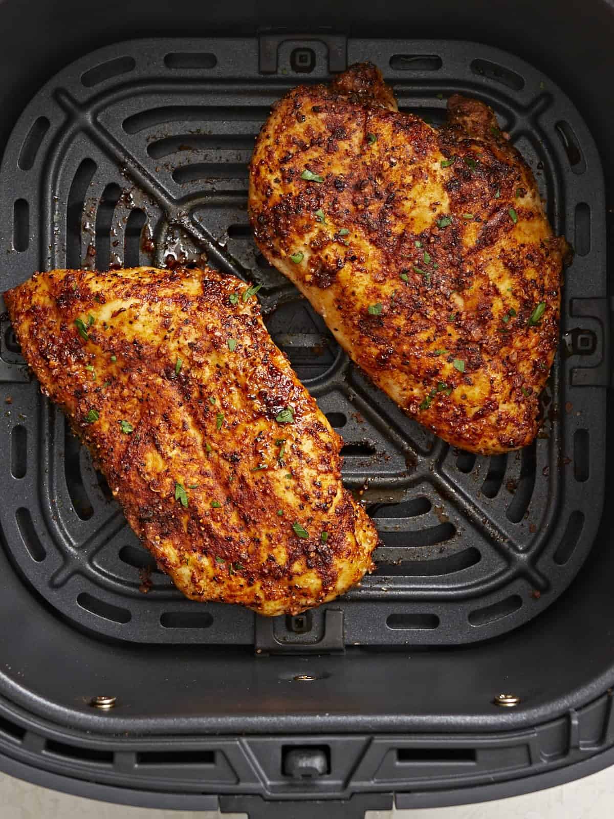 Cooked overhead view of Air Fryer Chicken Breasts in an air fryer basket.