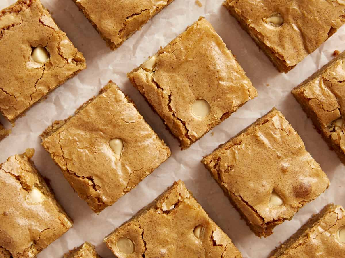 Close overhead view of blondies laying flat on parchment paper.