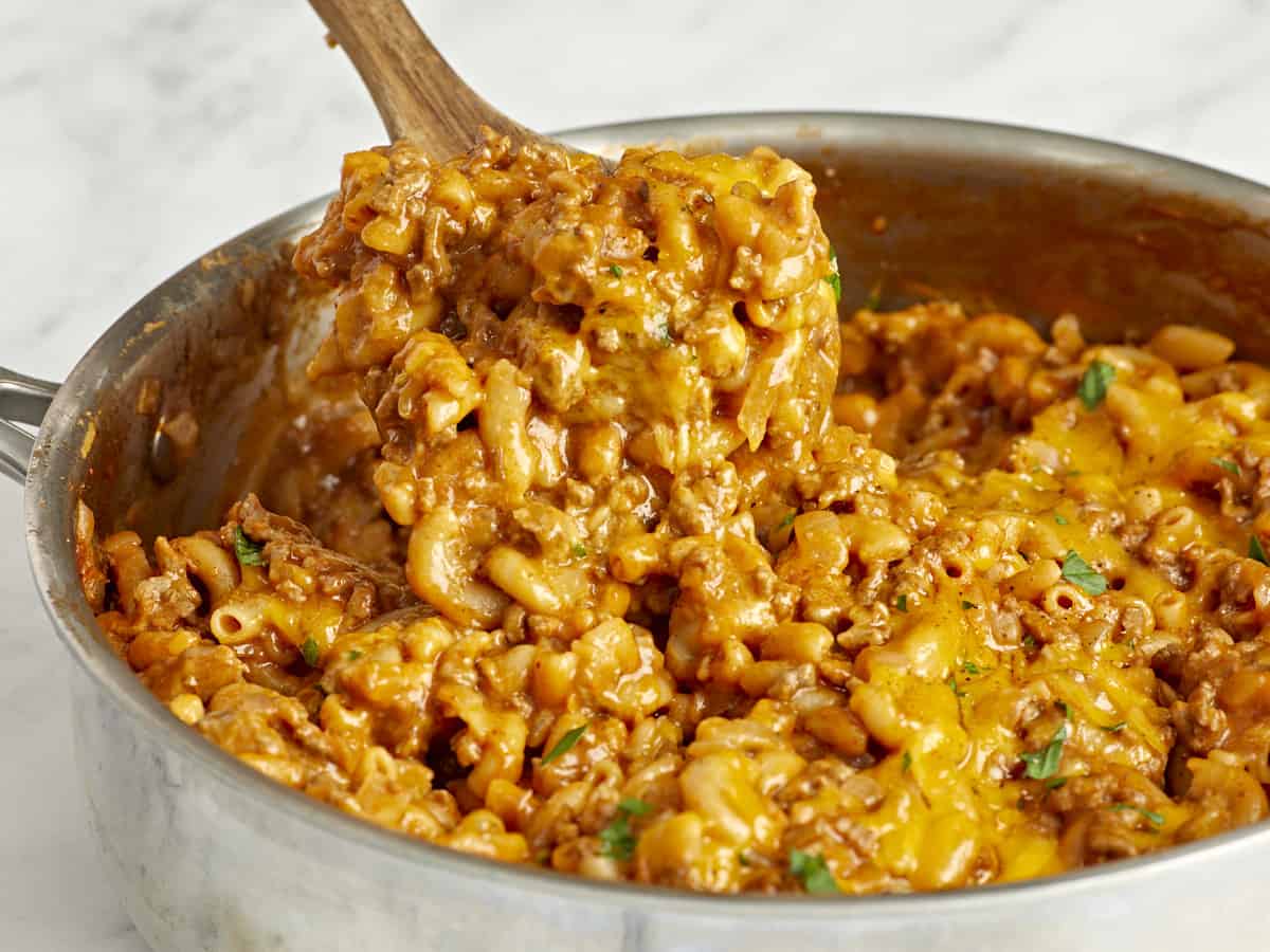 Side view of chili mac being scooped out of the skillet 