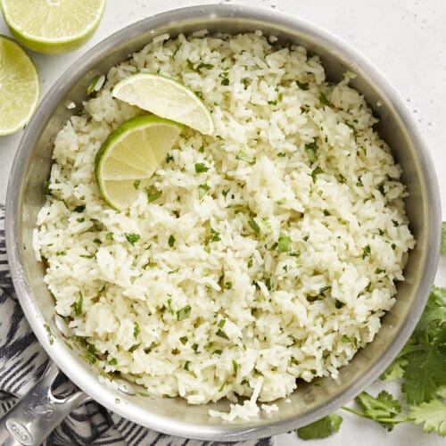 Cilantro lime rice in the pot with lime wedges.