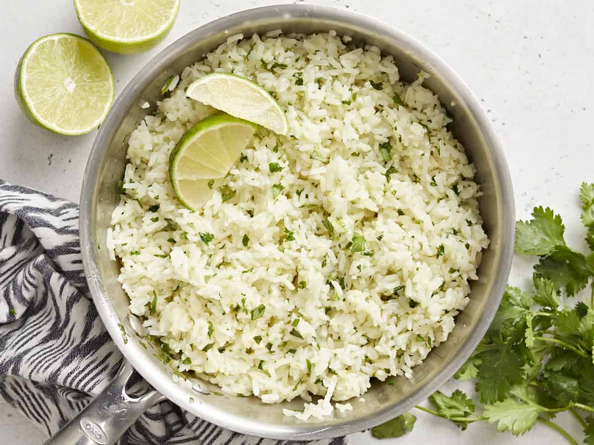 Cilantro lime rice in the pot with lime wedges. 