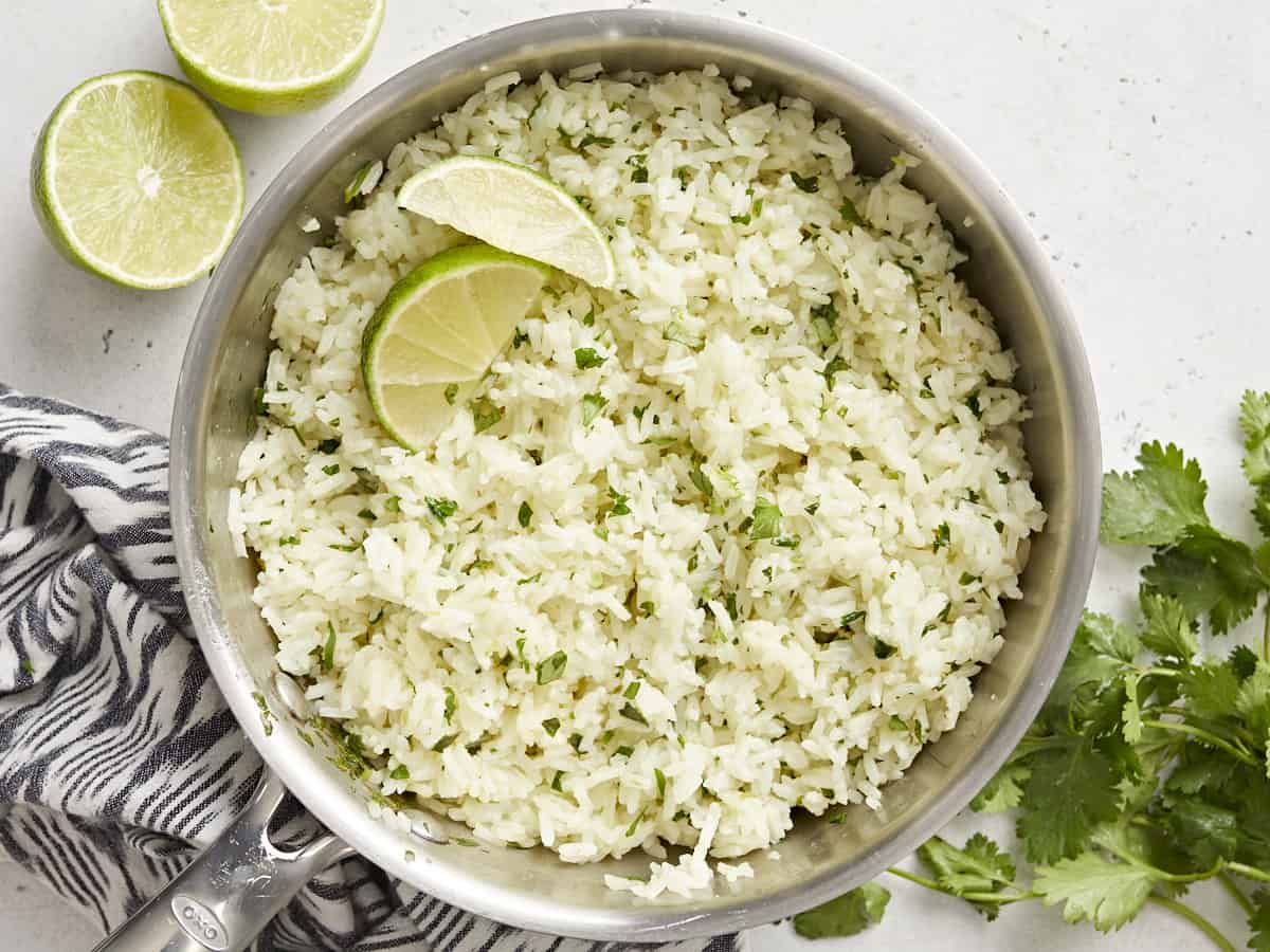 Cilantro lime rice in the pot with lime wedges.