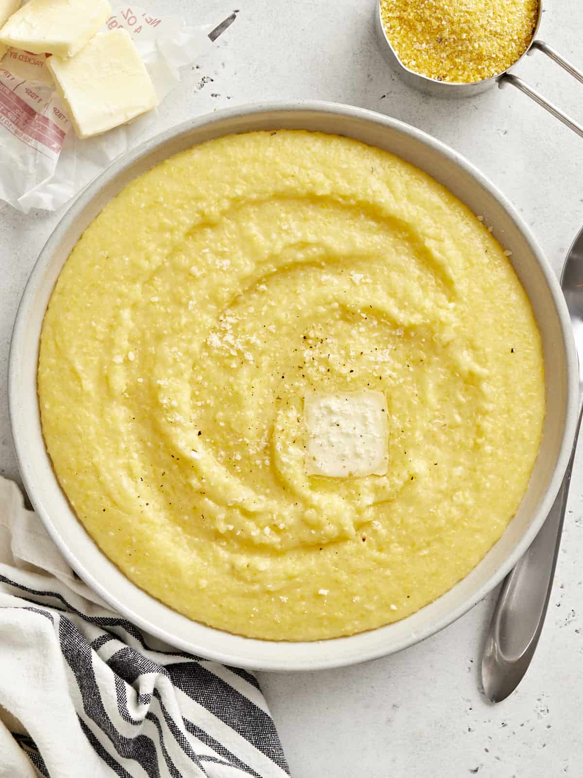 Overhead view of a bowl of polenta with a pat of butter on top.