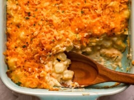 close up view of a wooden spoon in potato casserole.