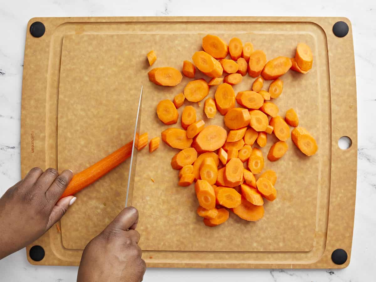 Carrots being cut on a cutting board.