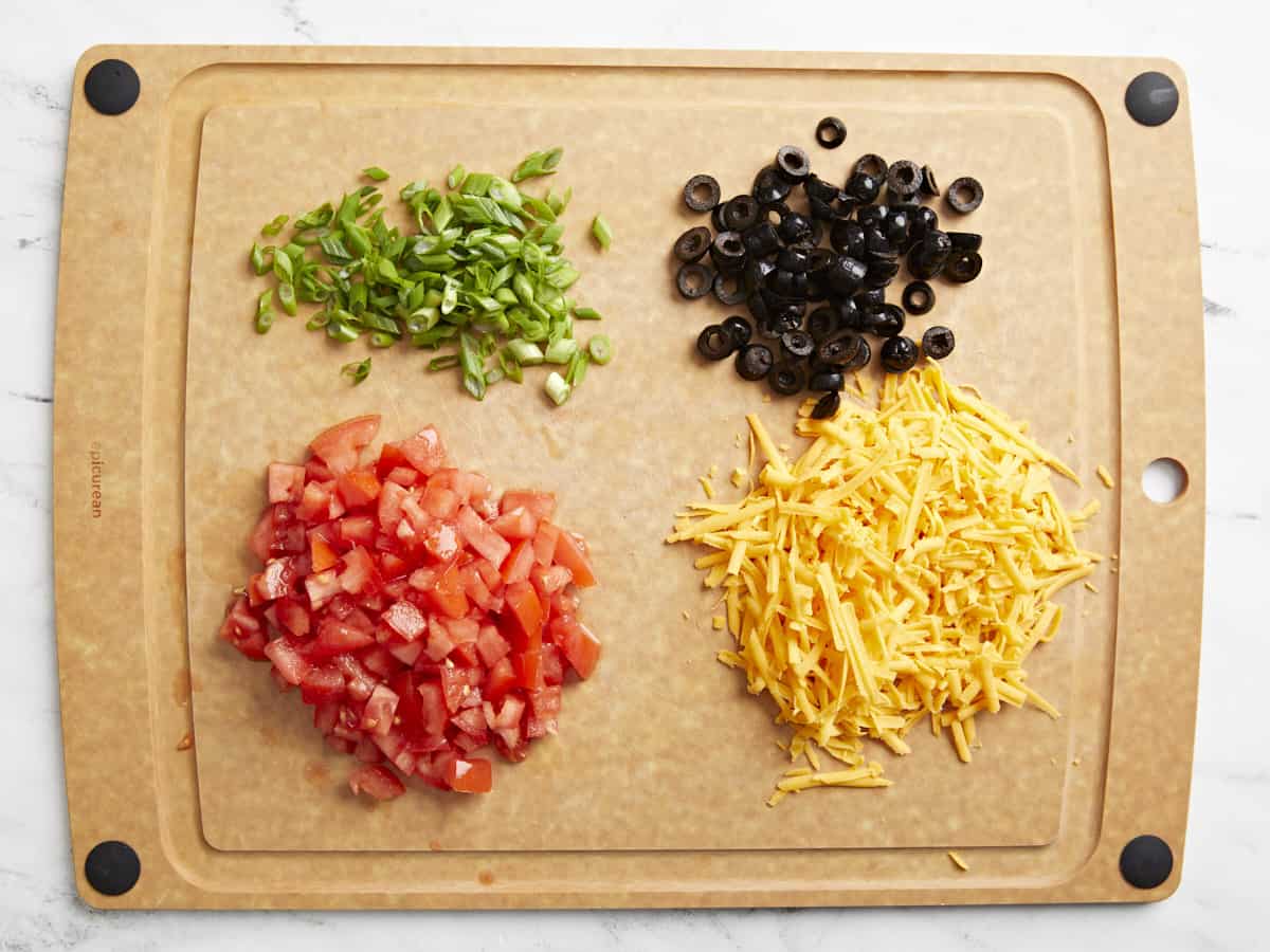 7 layer dip ingredients on a cutting board.