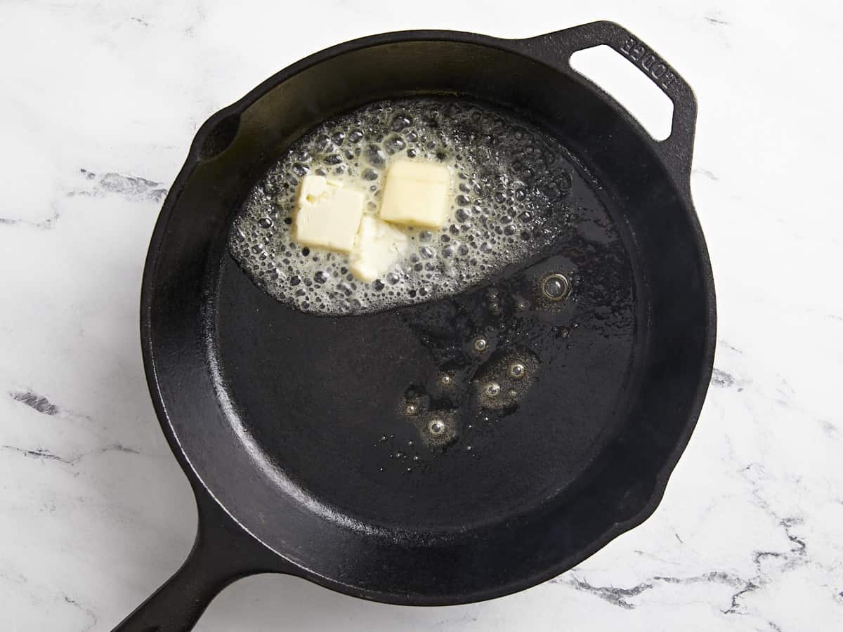Very hot cast iron skillet with melted butter in the center.