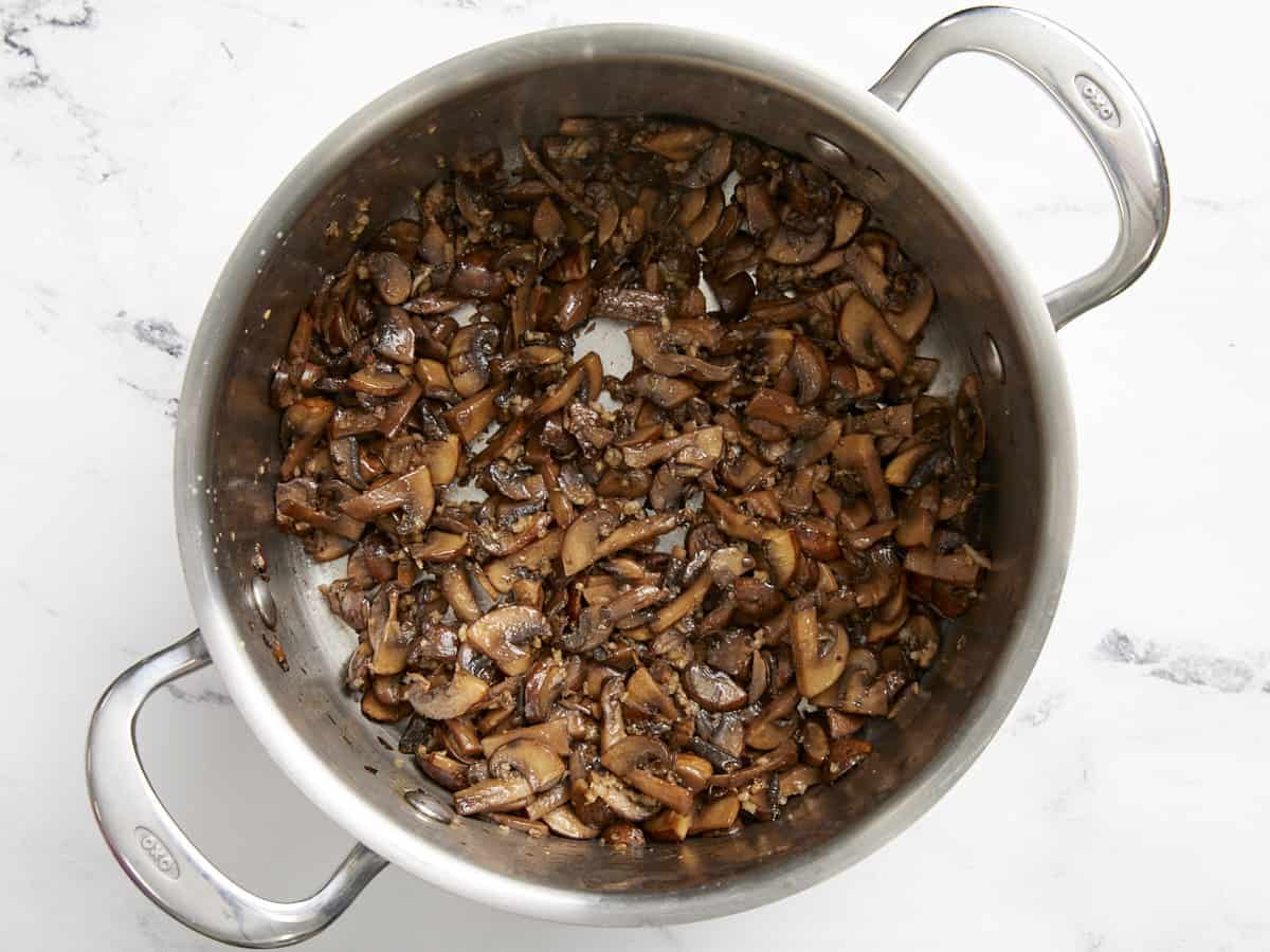 Sautéed mushrooms in a soup pot.