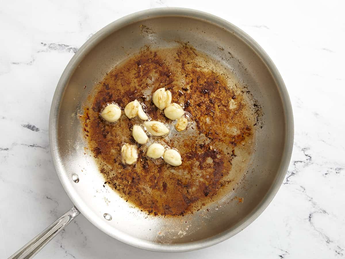 Garlic cloves sautéed in skillet with butter.