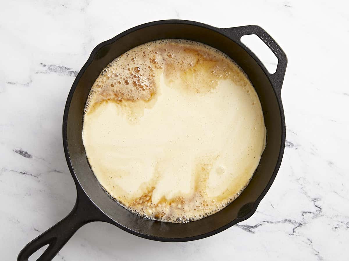 Dutch baby batter poured into hot cast iron skillet.