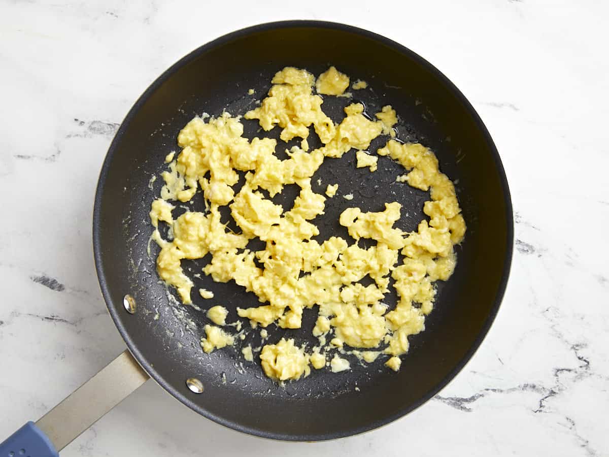 cooked scrambled eggs in a frying pan.