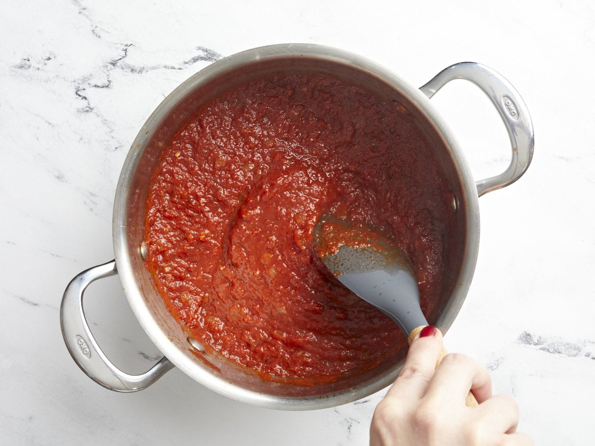 Marinara sauce being stirred in the pot.