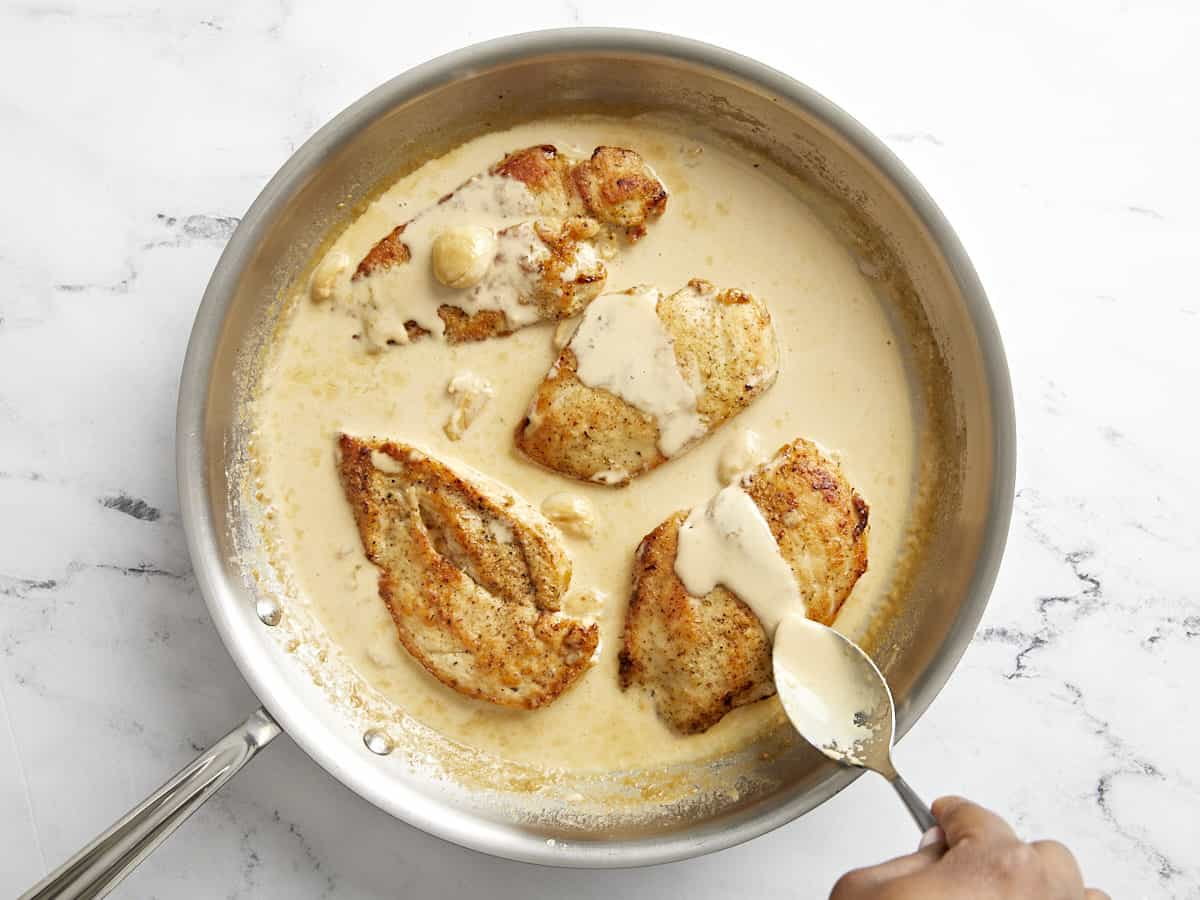 Chicken breasts added back to skillet and covered with creamy garlic sauce.