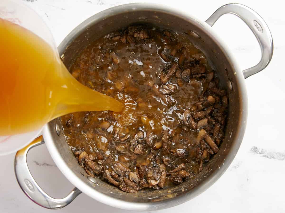 Vegetable broth being poured into the soup pot. 