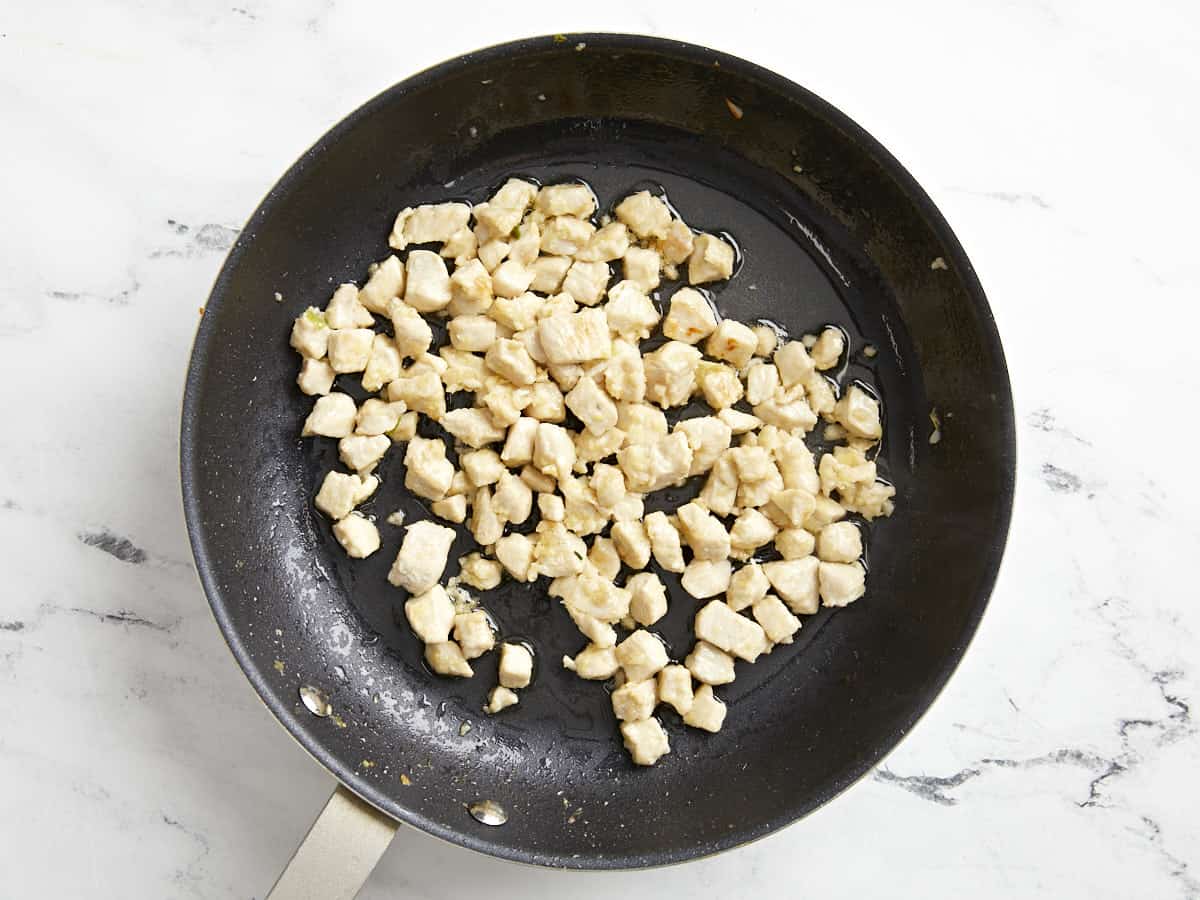 cooked cubed chicken in a frying pan.