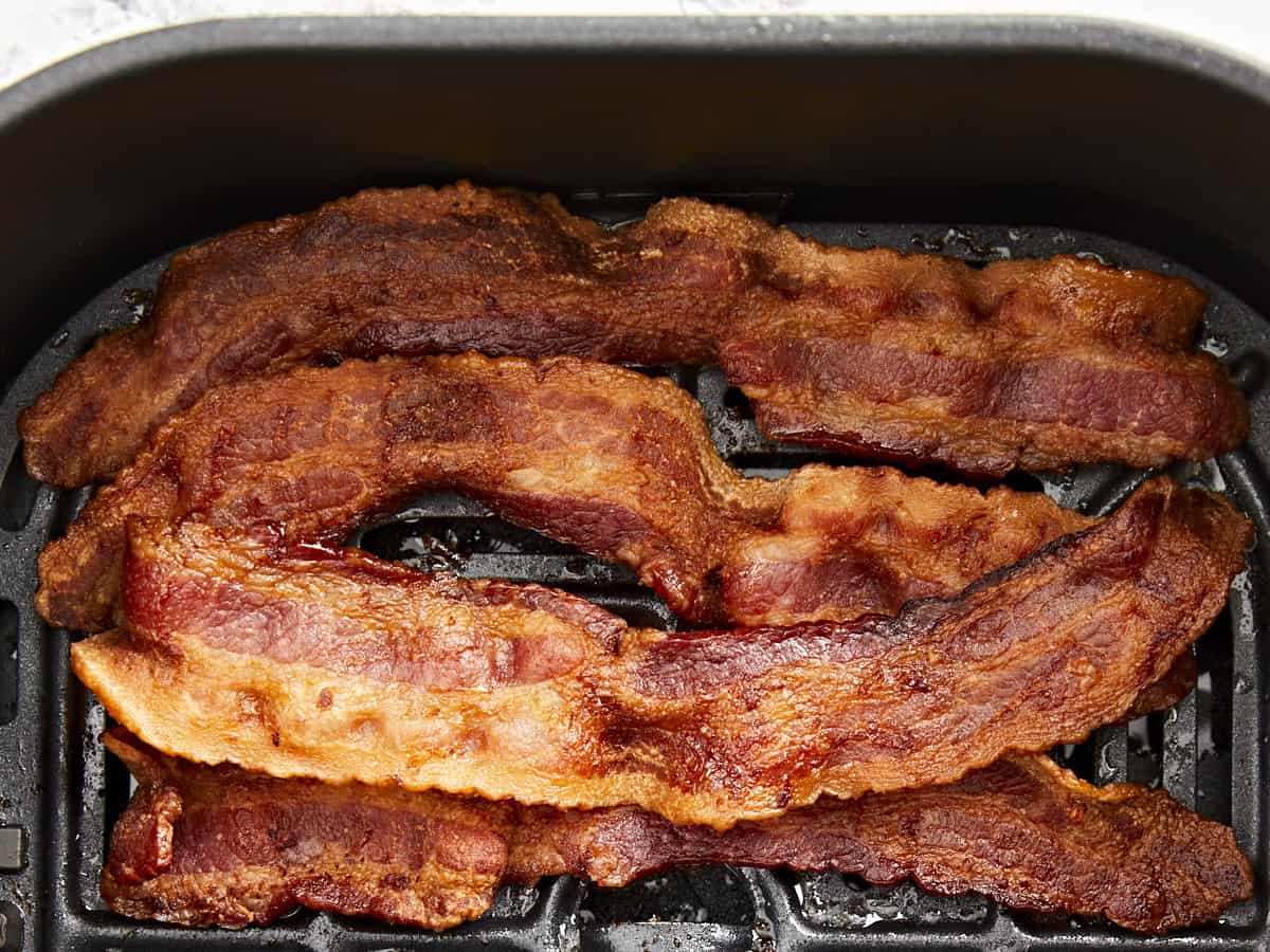 Overhead view of Air Fryer bacon cooked in an air fryer basket.