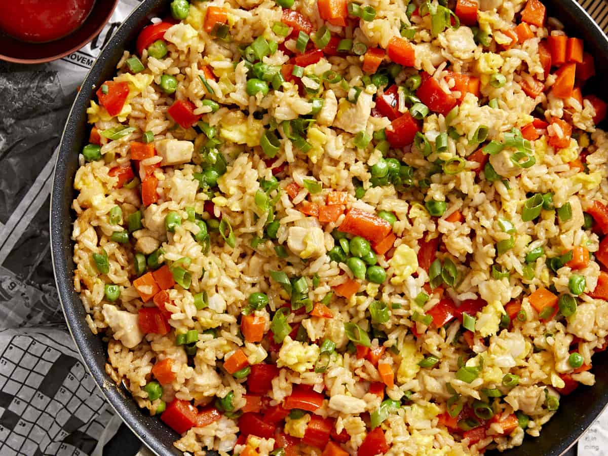 close-up overhead view of chicken fried rice in a frying pan.