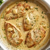 Overhead view of Creamy Garlic Chicken in a skillet with parsley garnished on top.