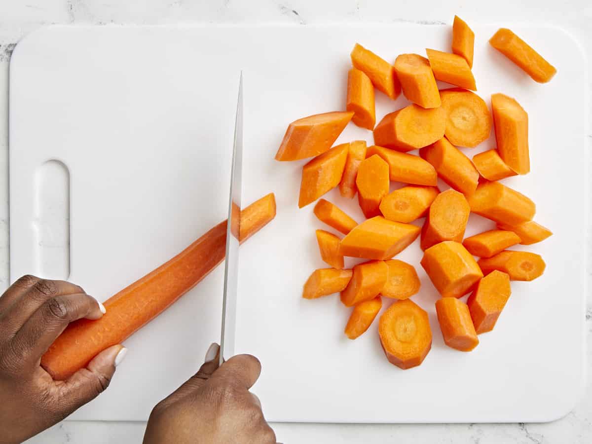 Carrots being chopped on a cutting board.