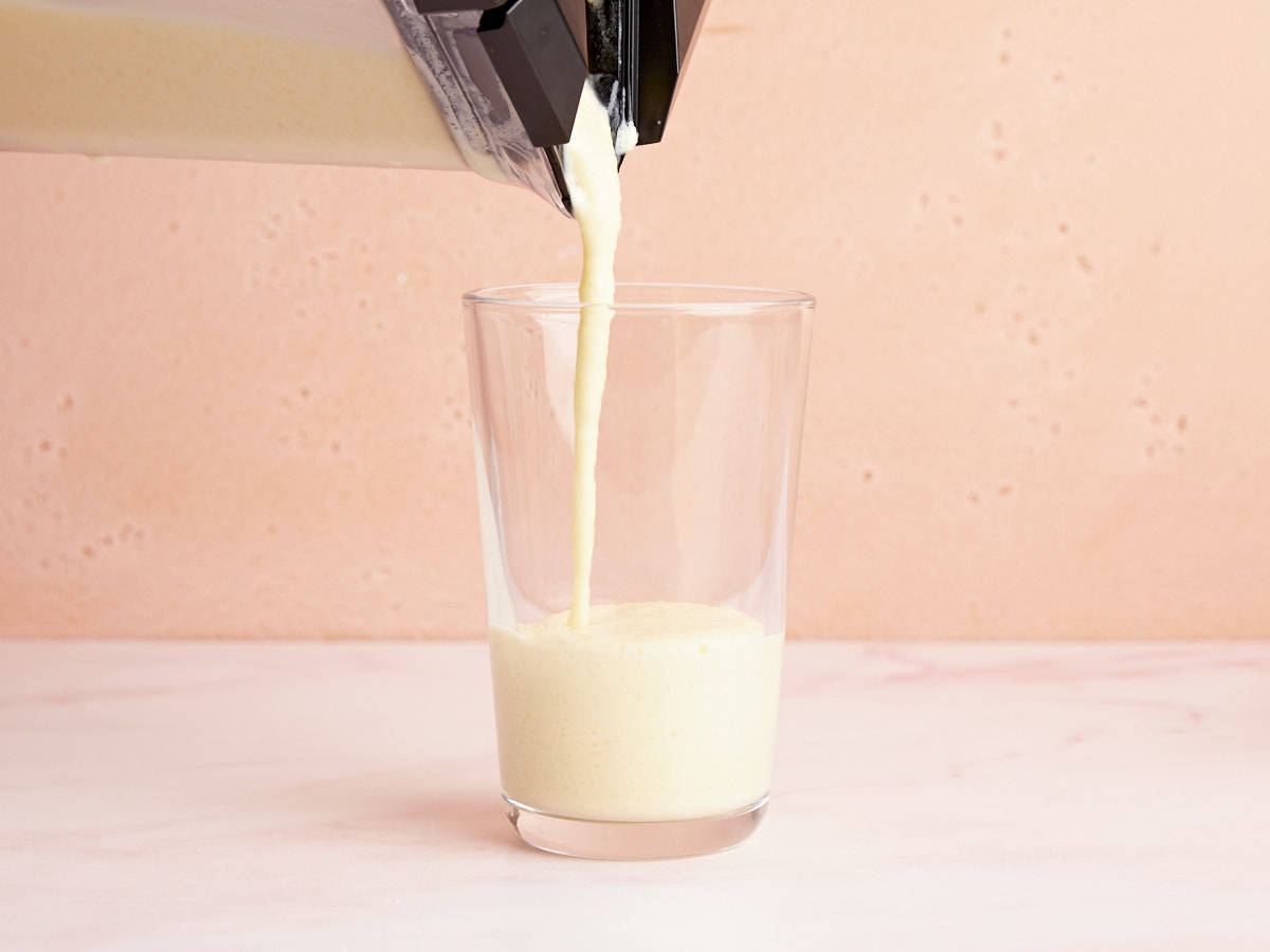 Orange Julius is poured from the blender into a glass. 