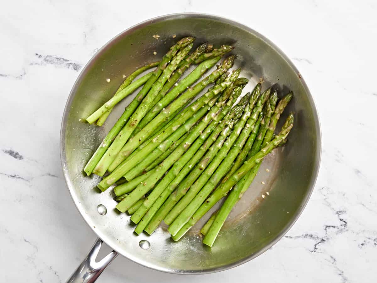 sautéed asparagus in a pan.