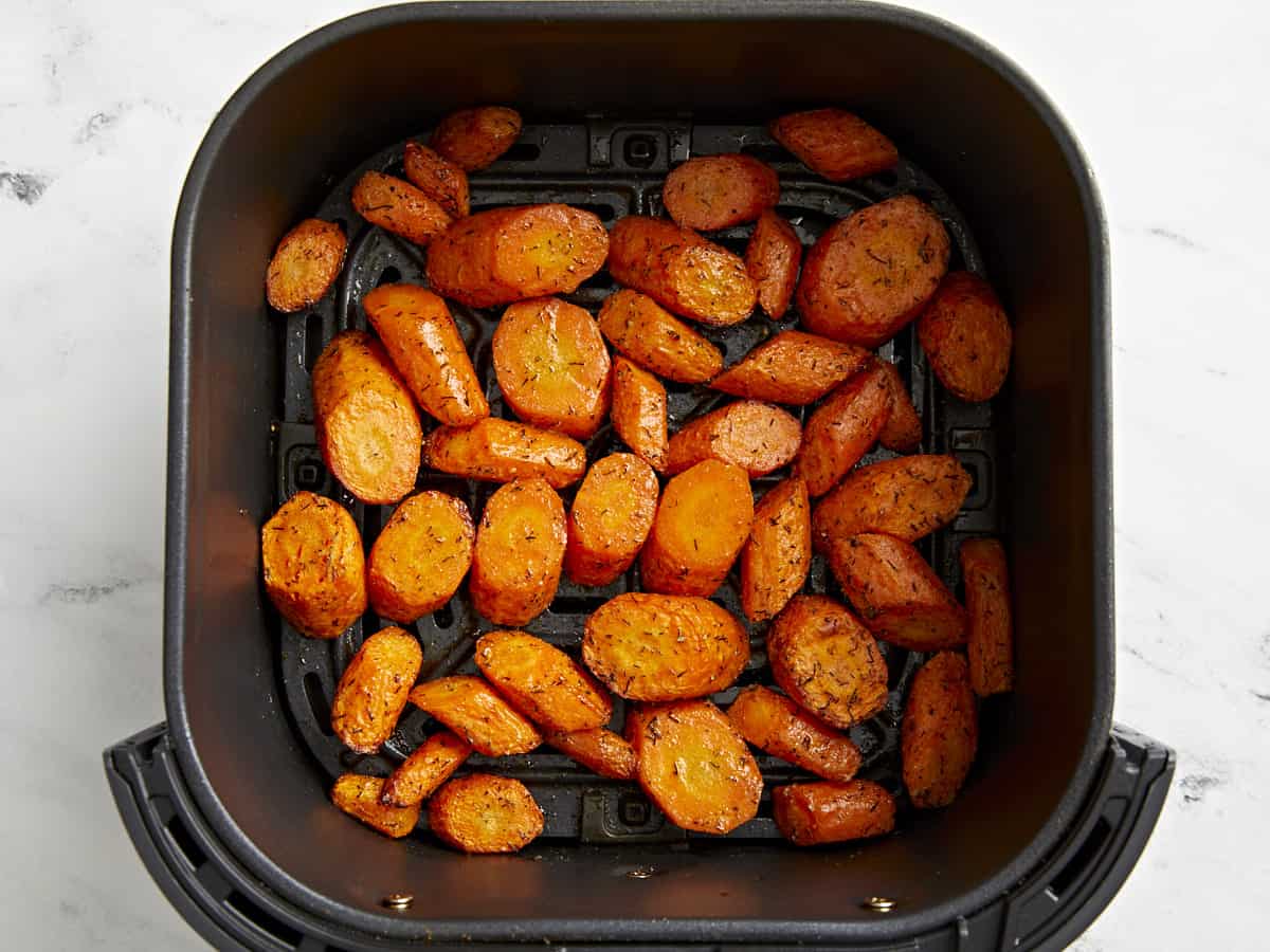 Cooked air fryer carrots in an air fryer basket.