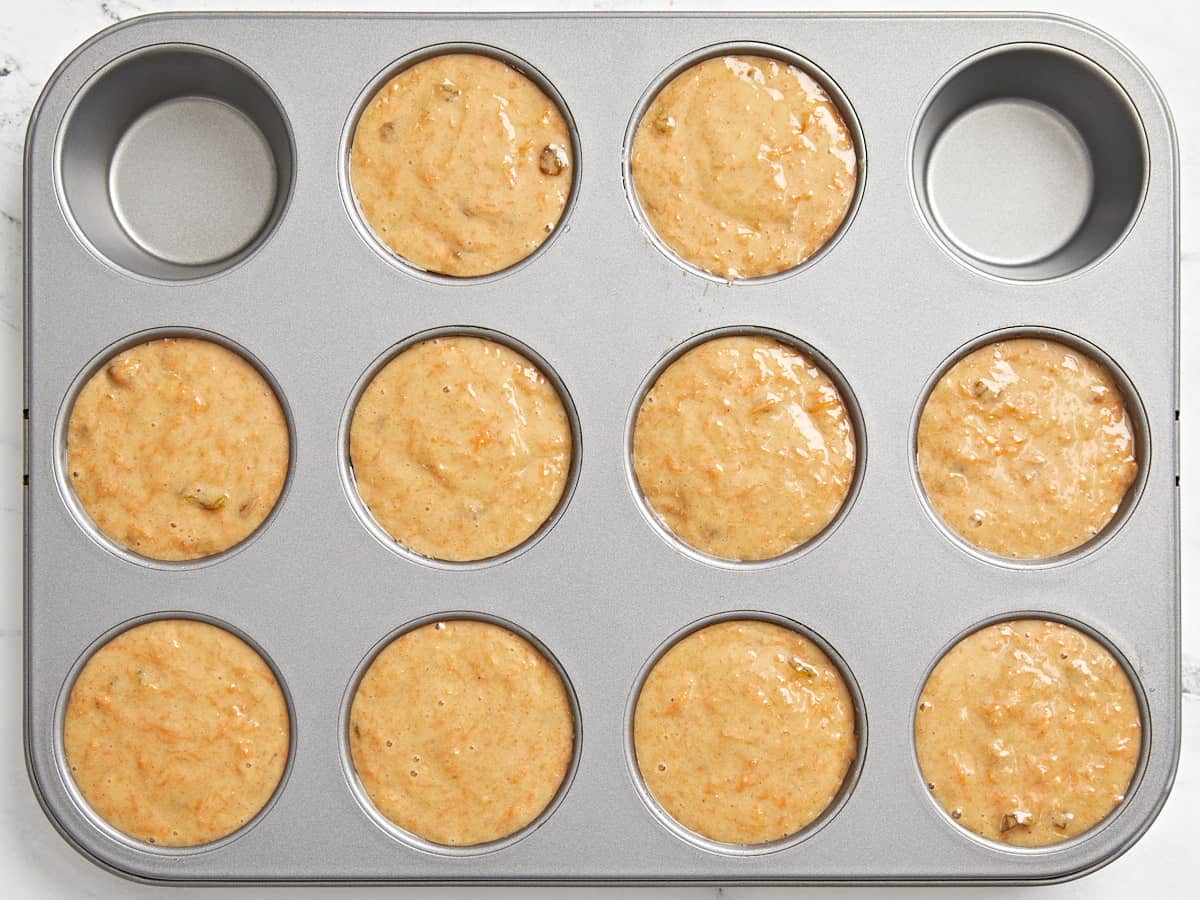 Carrot cake muffin batter added to muffin tins