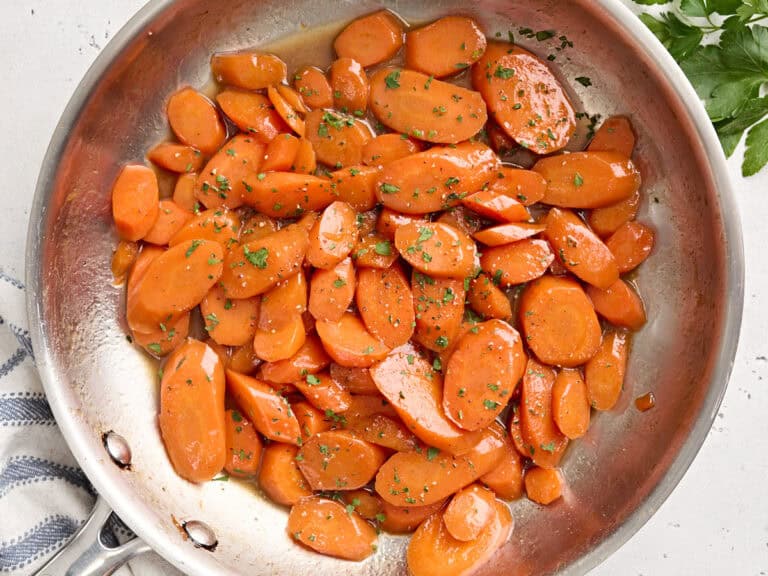 Overhead view of glazed carrots in a sauté pan.