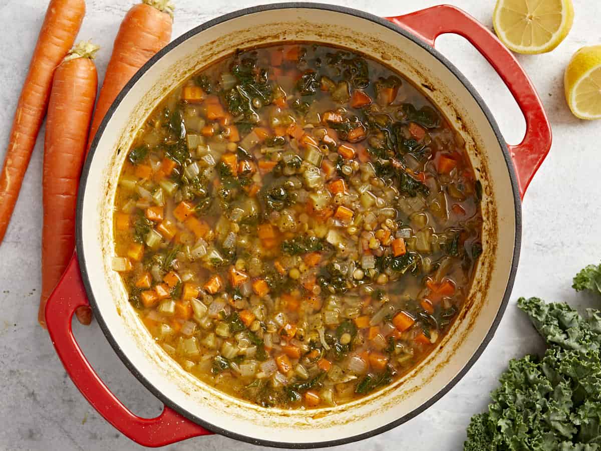 overhead view of mediterranean lentil soup in a red dutch oven.