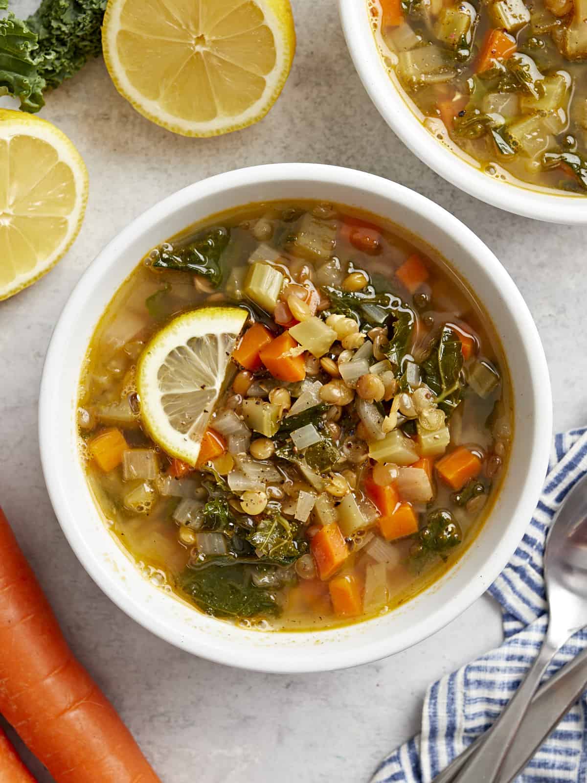 Top view of a bowl of Mediterranean lentil soup with lemon slices.