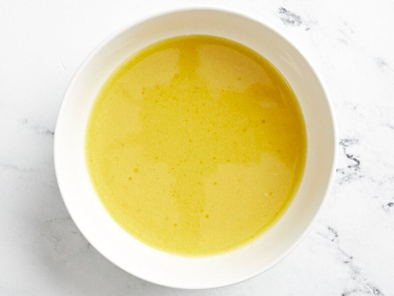 yellow dressing in a white bowl.