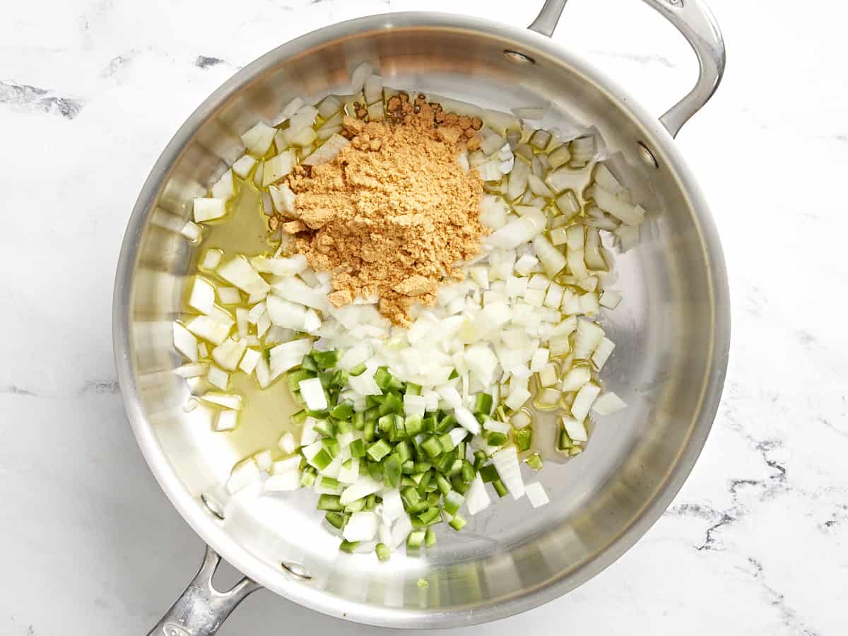 onion, jalapeno, and taco seasoning in a frying pan.