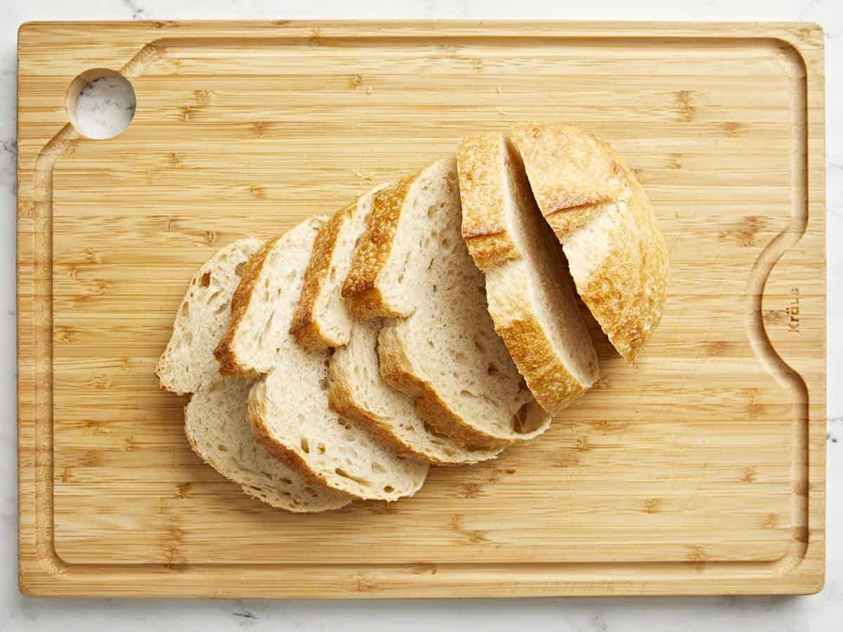 Overhead view of sourdough bread sliced on a cutting board.