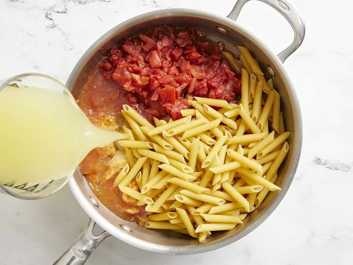 Add tomatoes, pasta and broth to the pan.