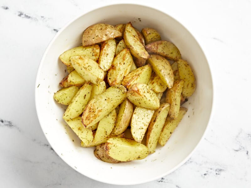 roasted halved baby potatoes in a white bowl.