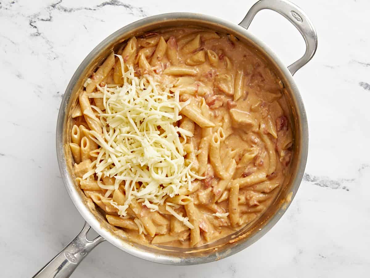 Shredded cheese added to the skillet.