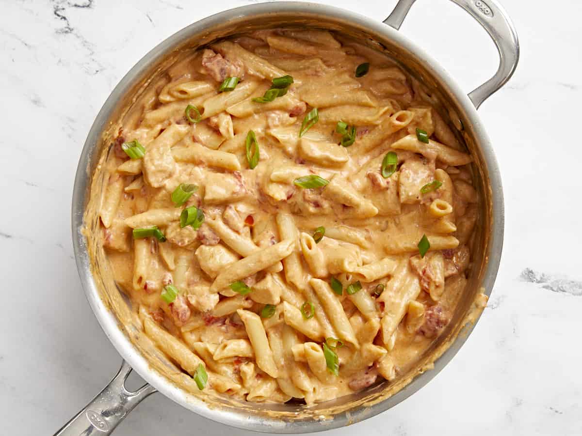 buffalo chicken pasta topped with sliced green onions. 