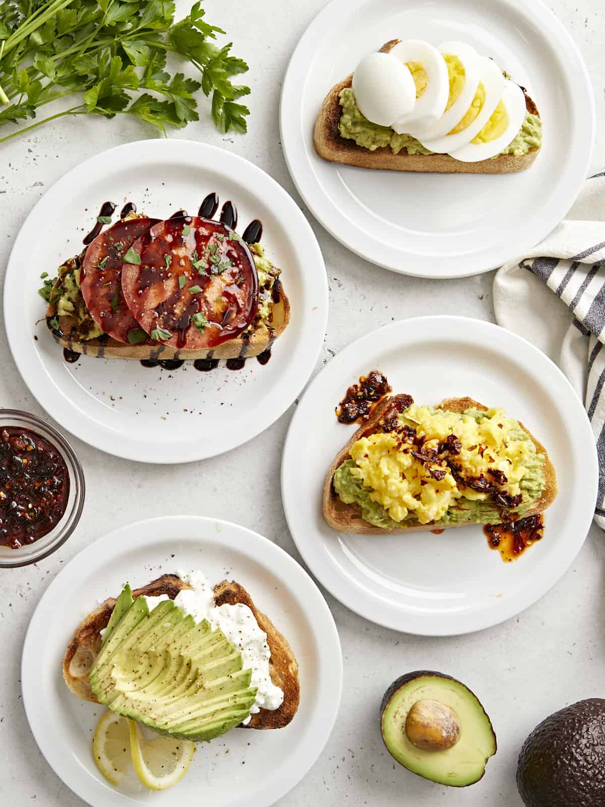 Overhead view of avocado toast made 4 different ways.