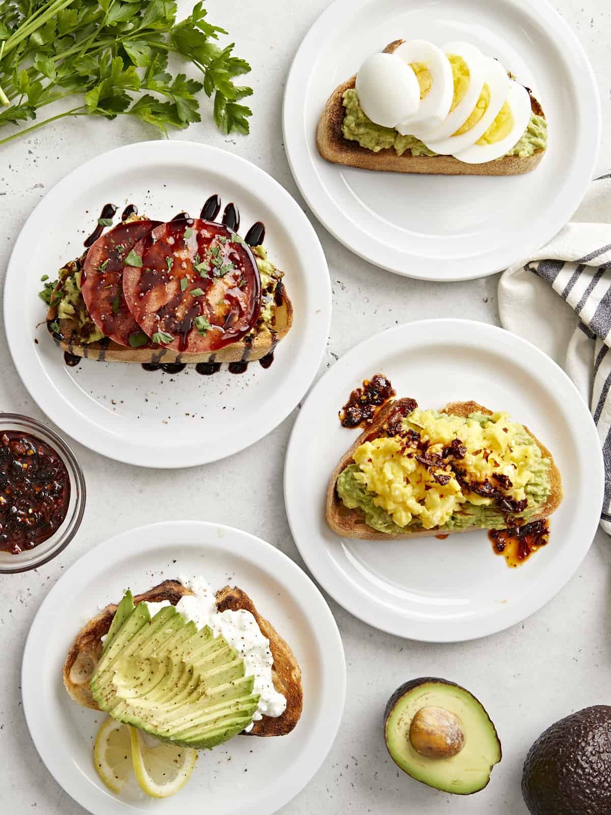 Top view of avocado toast prepared 4 different ways.