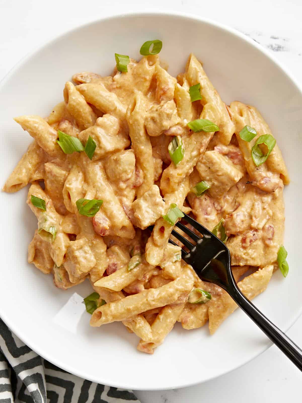 Close up overhead view of a bowl full of buffalo chicken pasta with a fork.
