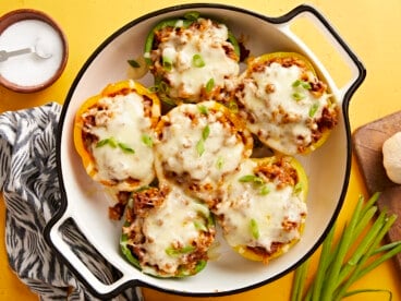 Overhead view of chorizo stuffed bell peppers in a round baking dish.