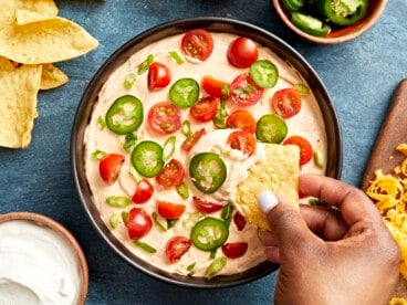 Overhead view of Taco Dip in a serving bowl with a chip scooping some out.