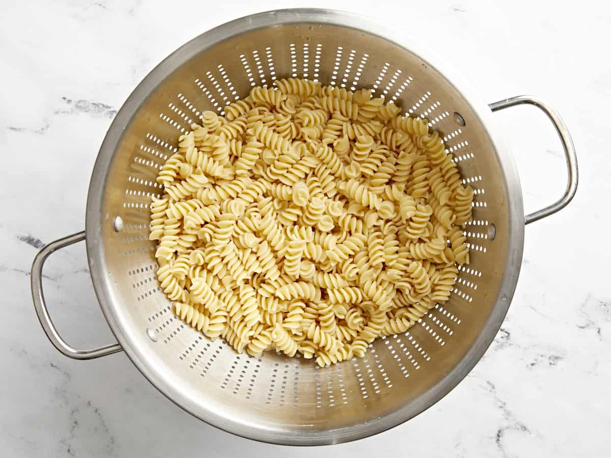 Cooked and drained rotini pasta in a colander.