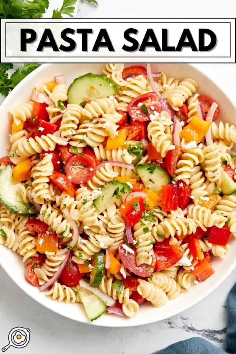 Overhead view of pasta salad in a large white serving bowl with title text at the top.