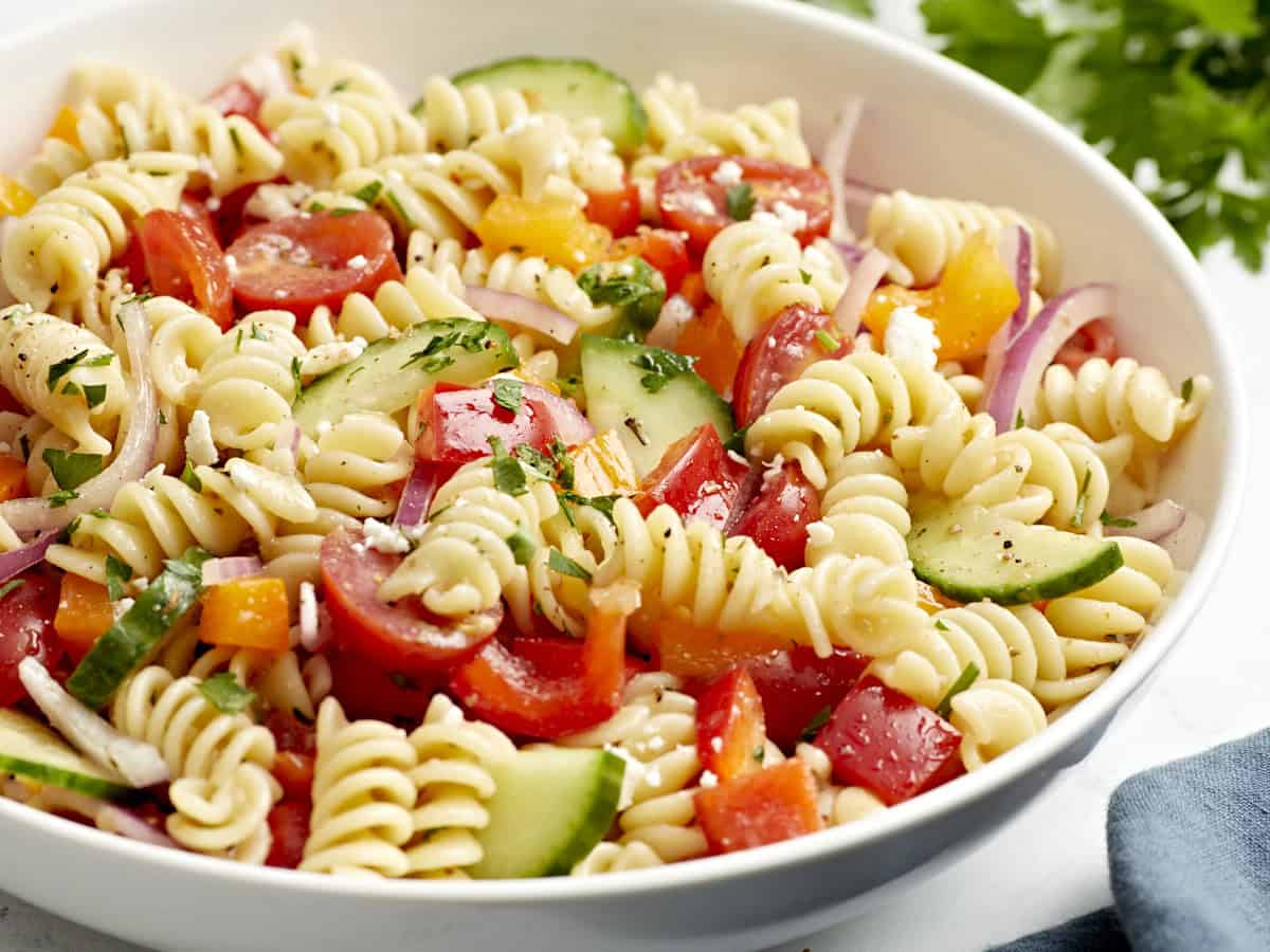 Side view of pasta salad in a white serving bowl.
