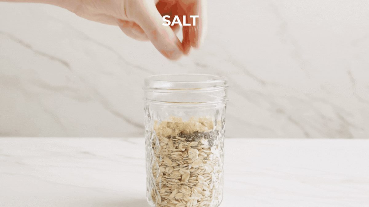 pouring milk into overnight oats mason jar